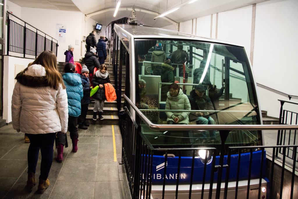 People getting on the Floibanen funicular for sledding.