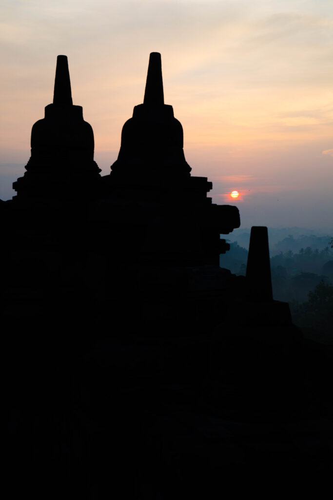 Borobudur stupas silhouetted at sunrise, Indonesia.