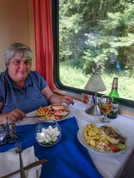 Corinne eating dinner in the dining car while enjoying train travel in Eastern Europe.