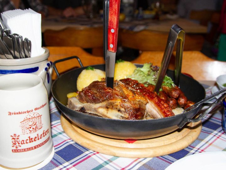 Table set with a pork shoulder dinner.