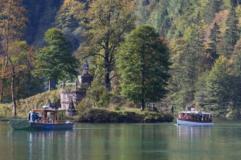 Boats gliding along the water in Königssee Germany.