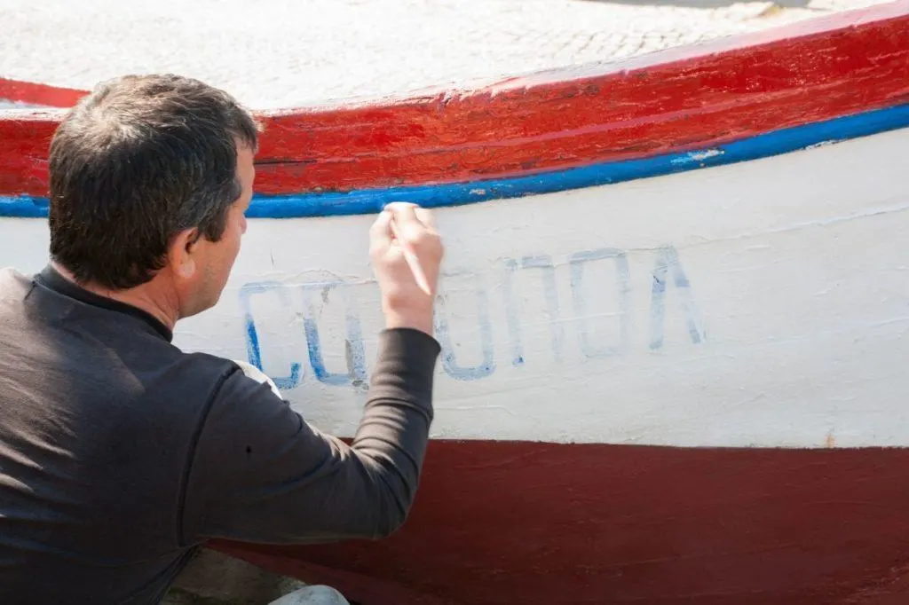 Man painting a boat. 