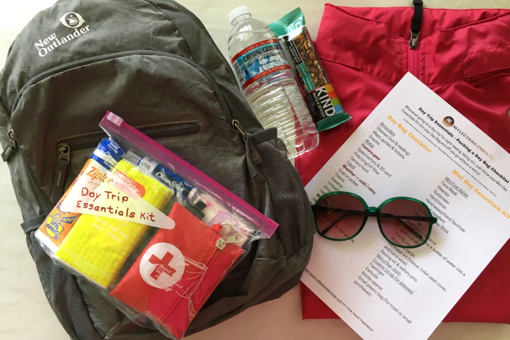 A day trip check list and a small day bag with items typically packed in a day bag.