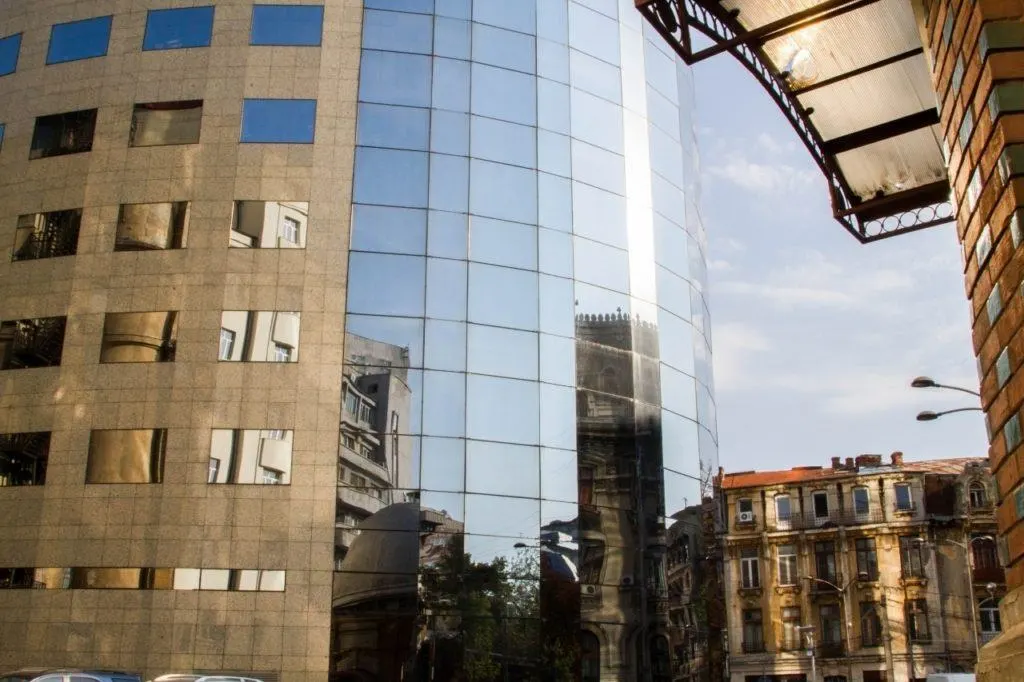Bucharest street scene reflected in a modern building.