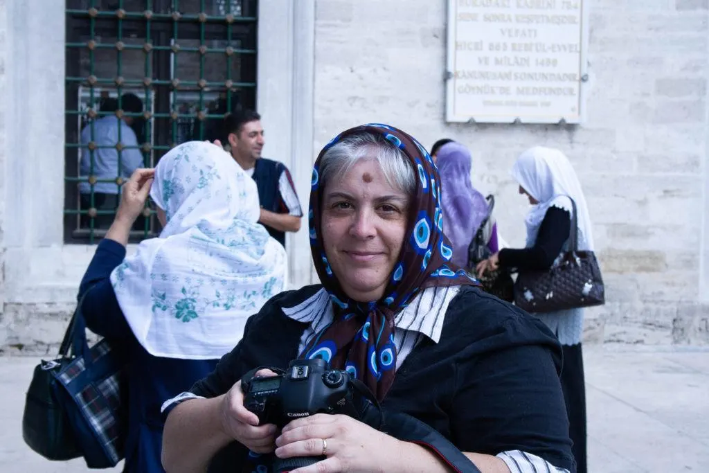 Women with camera in Istanbul wearing a Turkish evil eye scarf.