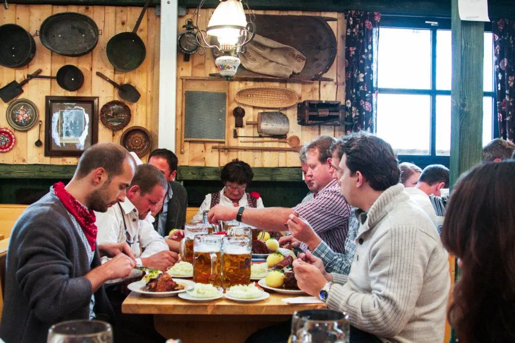 A group of people enjoying a meal in a typical German restaurant.