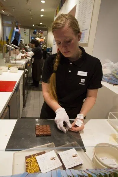 A women packaging chooclate bars at the make your won chocolate bar store.