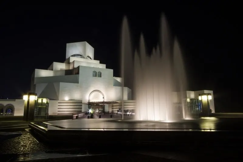 Museum Islamic Art Doha with fountains at night.