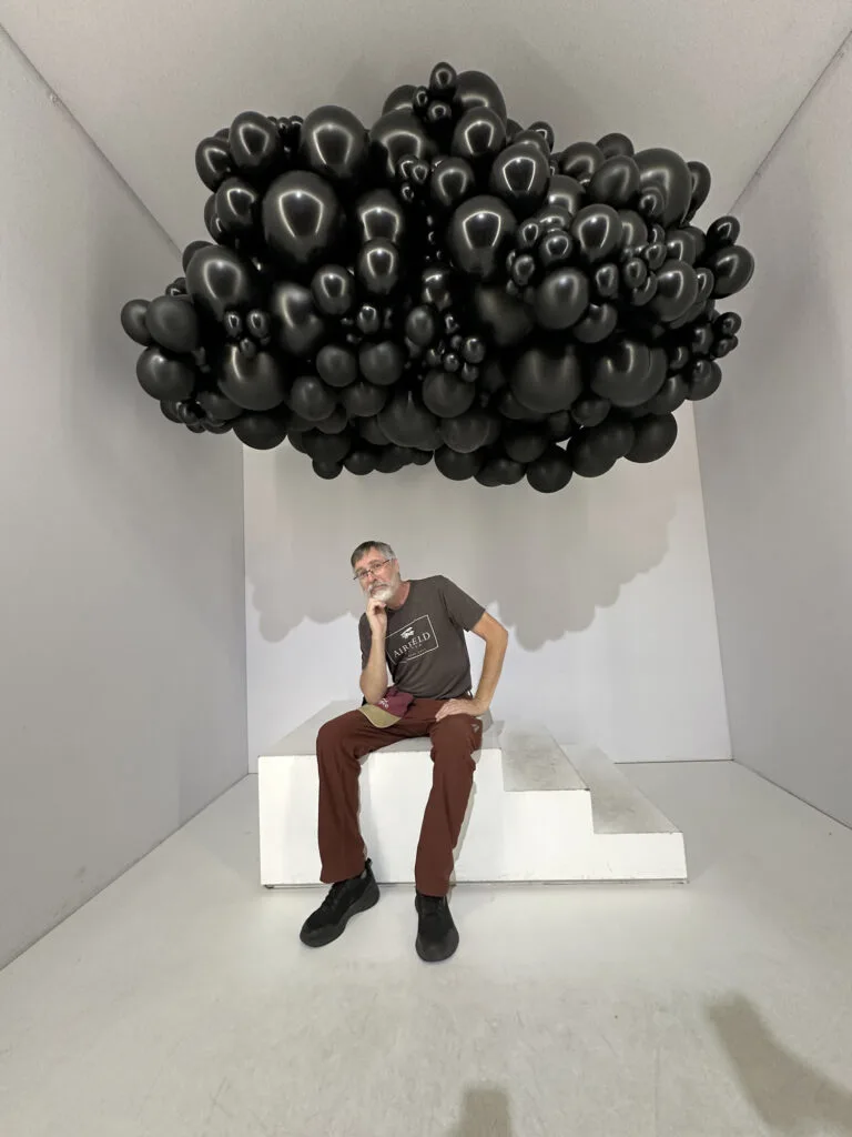 A cloud over Jim in balloons.
