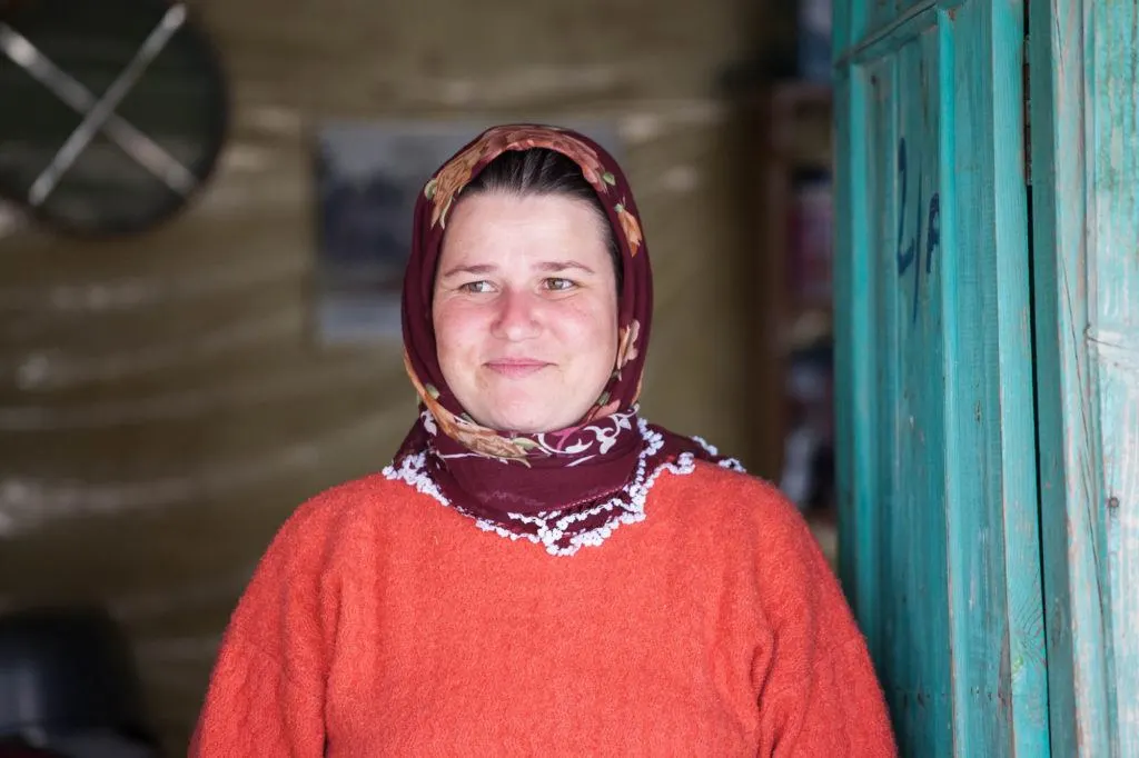 One of the village ladies standing in front of her blue door.
