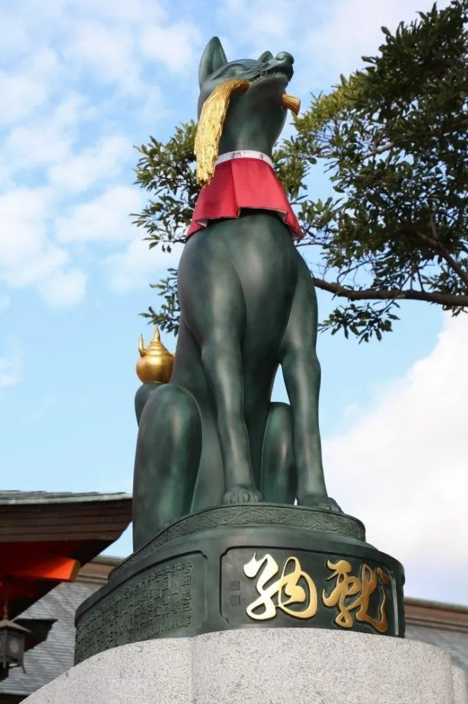 Closeup of guardian fox statue at Fushimi Inari shrine.