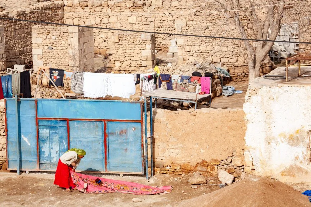 One Turkish woman cleaning a rug.