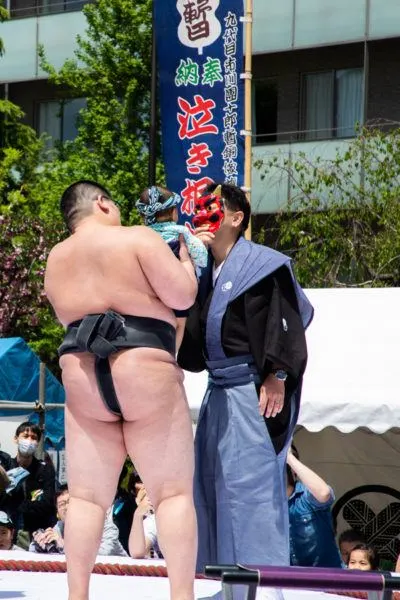 Trying to scare a particularly happy baby with a demon mask.