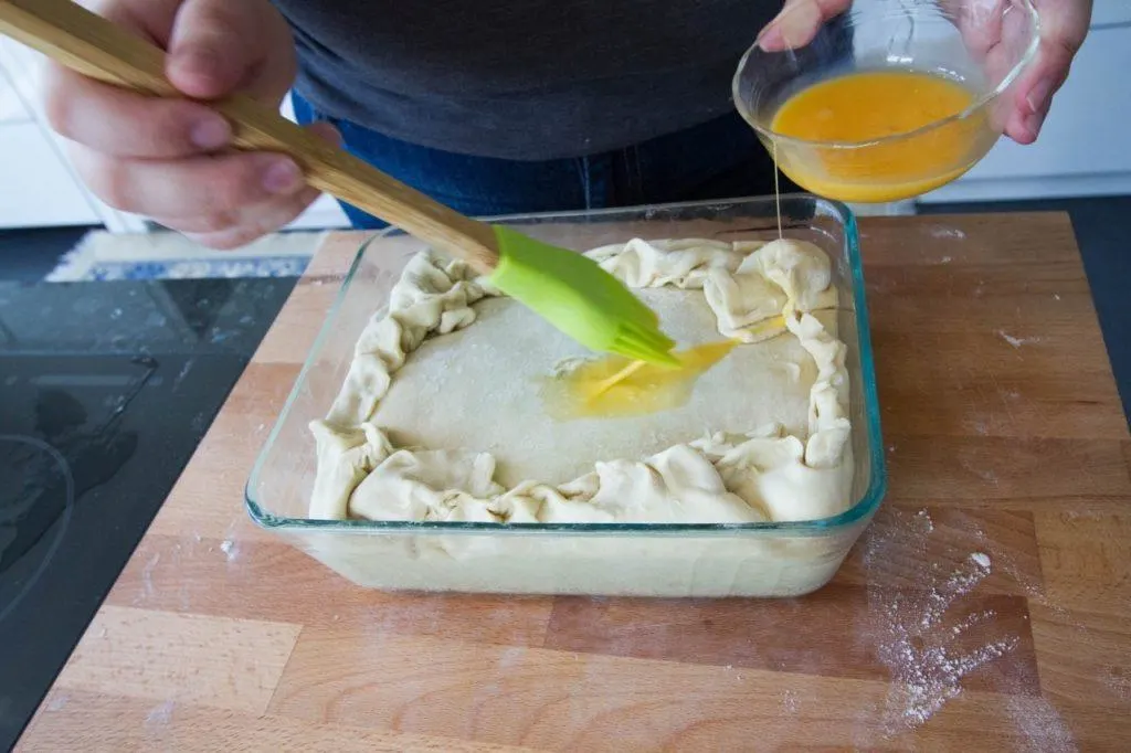 Brushing the pie with egg wash.