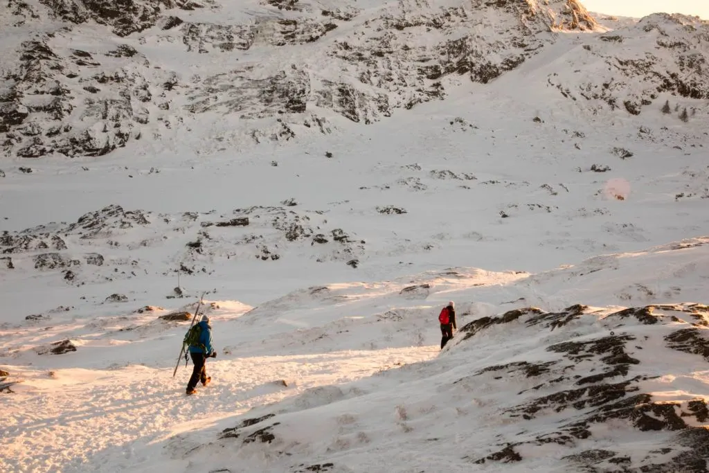 People hiking on a snow-covered trail in winter in Bergen where popular activities include skiing, snow-hiking, and sledding.
