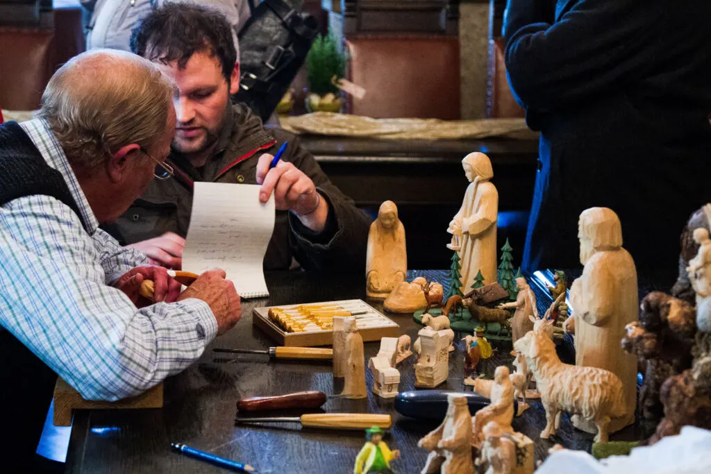 Local woodcarvers making a sale of their creche figurines.
