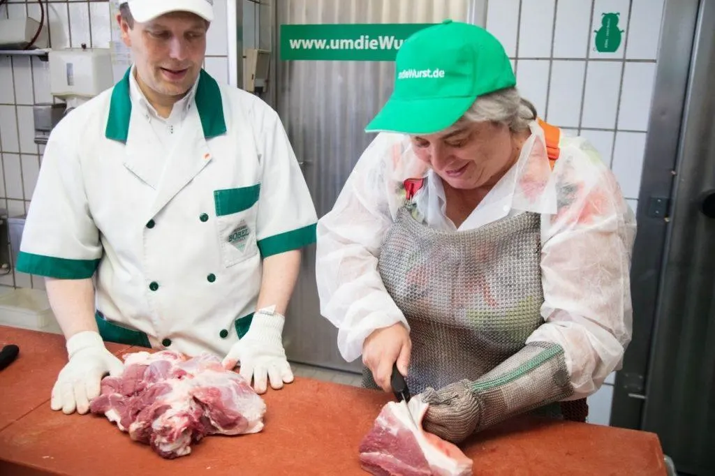 Corinne butchering some pork ribs with Claus standing by as we learn how to make wurst.