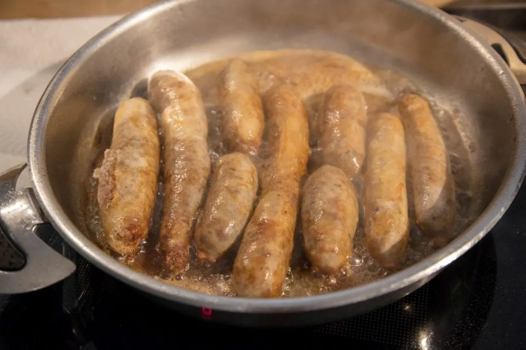 A pan of cooked homemade bratwurst after learning how to make wurst all day.